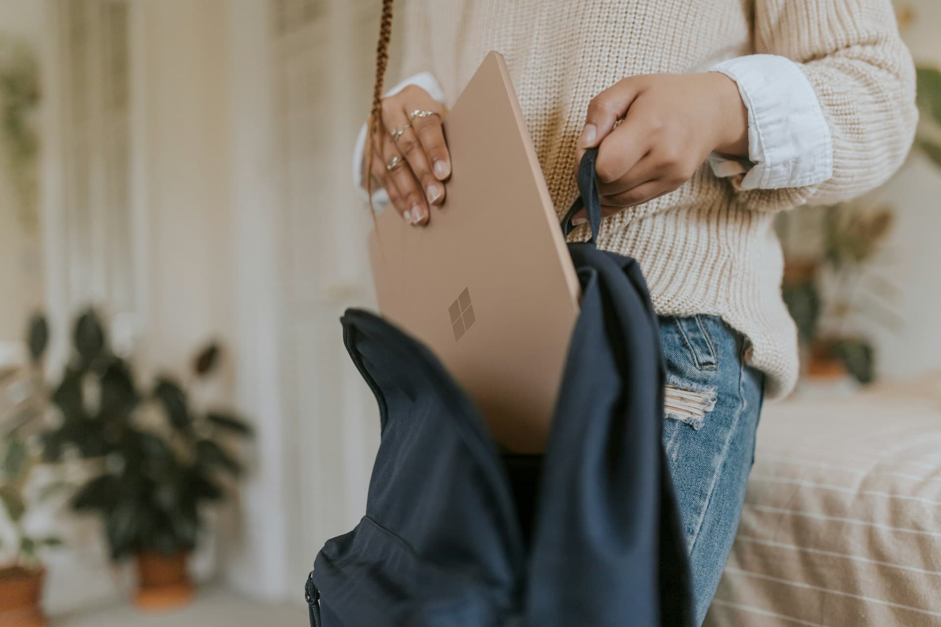 Person placing a laptop into a bag, ready to learn on the go